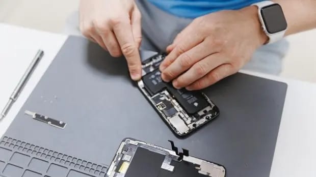 extend-phone-life-6-technician-replacing-smartphone-battery-on-a-mat-620x348