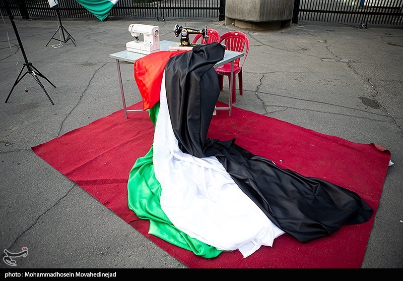 عکس‌ پربازدید از یک خانم با چرخ خیاطی مقابل دانشگاه تهران 