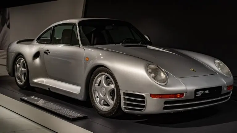 a-silver-porsche-959-on-display-in-a-museum-front-1-768x431