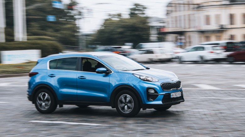 blue-kia-sportage-zipping-through-city-traffic-3