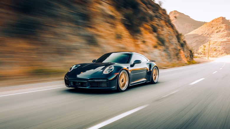 4-black-car-cruising-along-hills-with-blurred-background