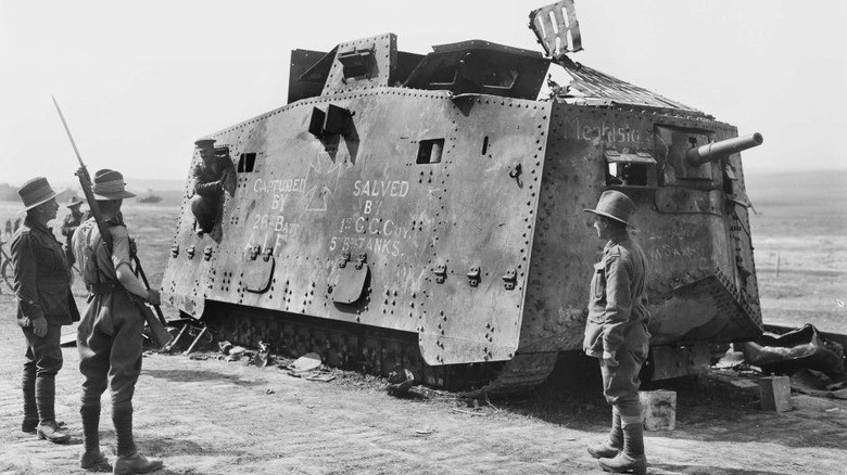 a7v-sturmpanzerwagen-history-1-black-and-white-three-soldiers-stand-around-a-part