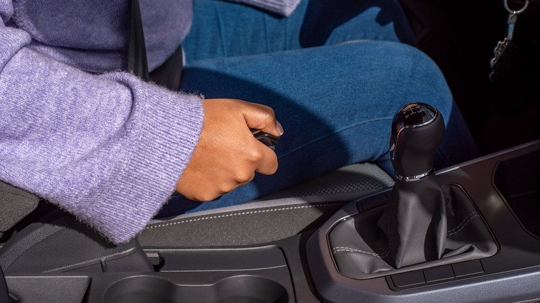 6-a-person-sitting-in-a-car-with-one-hand-pulling-up-on-the-parking-brake-lever