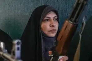 لباس صورتی یک زن جانفدا در حالی که اسلحه دست دارد