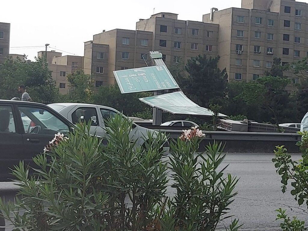 سقوط تابلوی مسیرنما بر روی خودروها در تهران