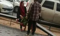 تصویری از دختر گل‌فروش با لباس مردانه