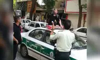 پشت‌پرده نشستن یک زن روی سقف ماشین پلیس