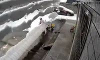 ریزش وحشتناک انبوه برف از پشت‌بام روی یک زن