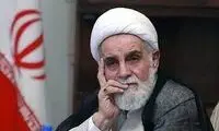 ناطق نوری با لباس شخصی بر مزار شجریان