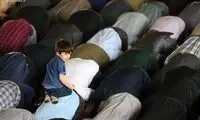 بازیگوشی یک کودک در هنگام نماز خواندن پدر