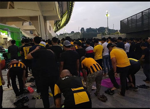 نماز جماعت هواداران مالزیایی پیش از آغاز بازی