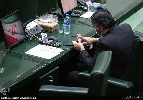 یک نماینده در حال تمیز کردن موبایل در مجلس