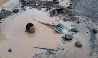 پشت پرده عکسی از فداکاریِ یک کارمندِ غرق در آب