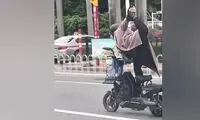 دختر نقابداری که روی موتور، یوگا کار می‌کند!