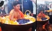 ویدئویی عجیب از کودک هندی نشسته در دیگ آب جوش!