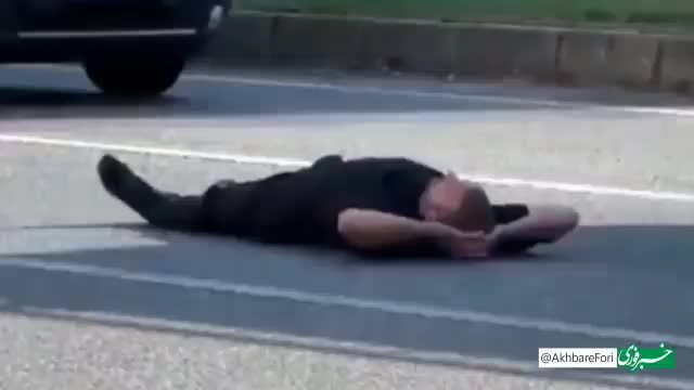 دراز کشیدن دیوانه‌وار یک مرد در وسط خیابان