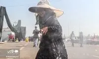 تصاویرِ خنک کردن زائران اربعین در گرمای شدید